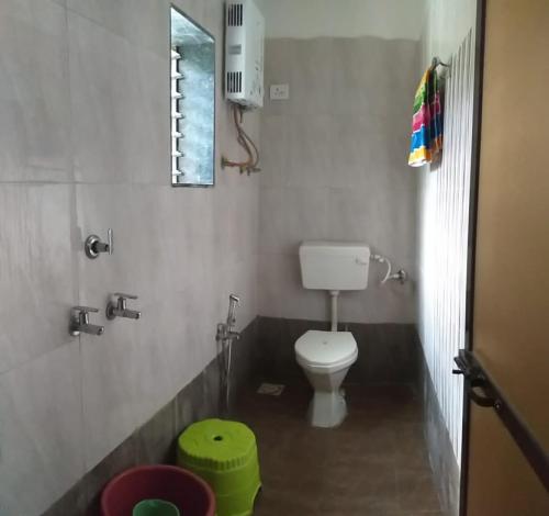 a bathroom with a white toilet in a room at Kshanbhar Vishranti Home Stay in Malvan