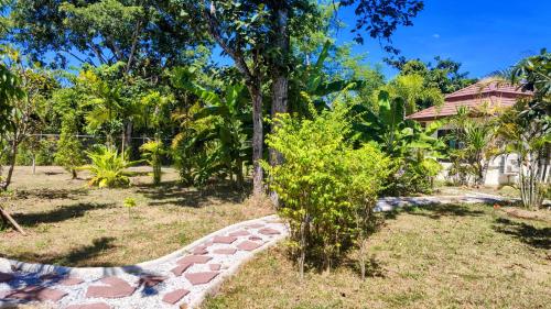 a garden with a stone path in front of a house at Isan Golf & Adventure Hotel in Udon Thani