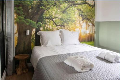 Natuurhuis Dichtby في Rucphen: غرفة نوم عليها سرير وفوط