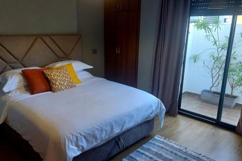 a bedroom with a bed and a sliding glass door at Appartement avec piscine et jacuzzi privé in Casablanca