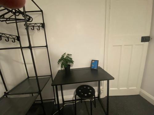 a room with a table and a plant on a shelf at Peaceful stay Derby Single Room in Derby