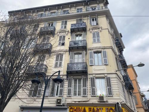 un edificio alto con ventanas y balcones en una calle en Rentomatique Studio Jean Médecin, en Niza