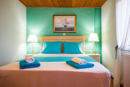 um quarto com uma cama com duas almofadas azuis em Zoina's House em Leptokarya