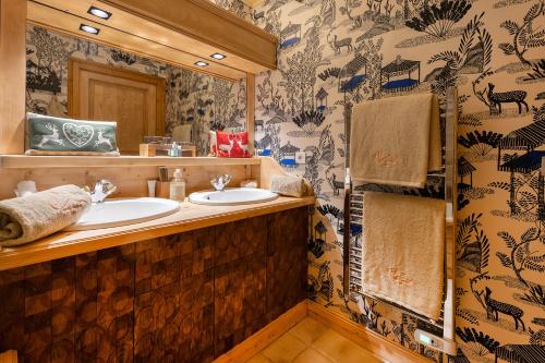 a bathroom with two sinks and a mirror at Magic Megève Bois in Demi-Quartier
