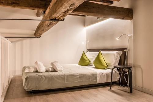 um quarto com uma cama com duas almofadas verdes em Ca' Nova @San Marco em Veneza