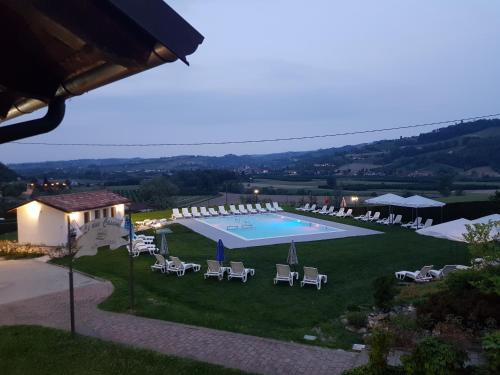 einen Blick über einen Pool mit Liegestühlen in der Unterkunft Agriturismo Le Due Cascine in San Marzano Oliveto