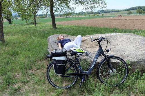 a person laying on a rock next to a bike at Appartement ROSalia in Forchtenstein