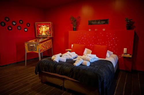 um quarto vermelho com uma cama com toalhas em L'INDUS - Le Domaine Wambrechies em Wambrechies