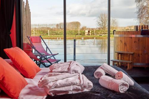 a bed with towels and a view of a lake at L'INDUS - Le Domaine Wambrechies in Wambrechies