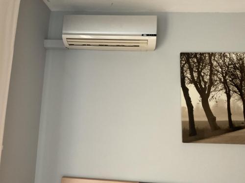 a white air conditioner on a wall in a room at Casa con Gran Piscina particular cerca playa in Torredembarra