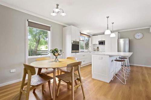 a kitchen and dining room with a table and chairs at Bluelake Retreat in Metung