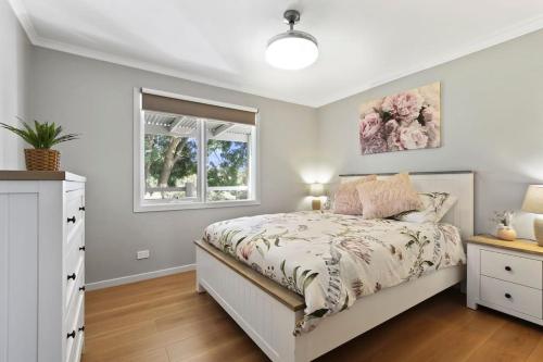 a bedroom with a bed and a window at Bluelake Retreat in Metung