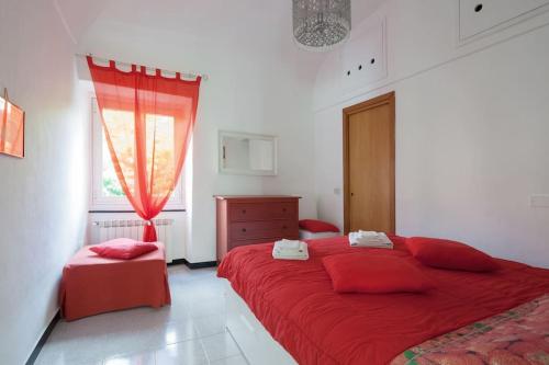 a bedroom with a red bed and a window at Beatrice Nel centro di Levanto in Levanto
