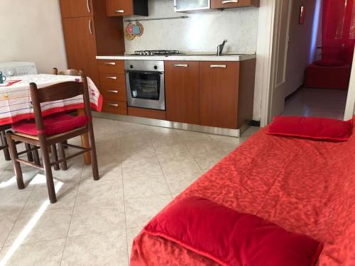 a kitchen with a table and a red bed in a room at Beatrice Nel centro di Levanto in Levanto