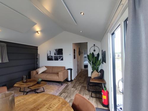een woonkamer met een bank en een tafel bij Chalet IJssel Eilanden Kampen Waterfront Airco in Kampen