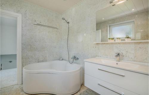 a white bathroom with a tub and a sink at Nice Home In Njivice With Wifi in Njivice