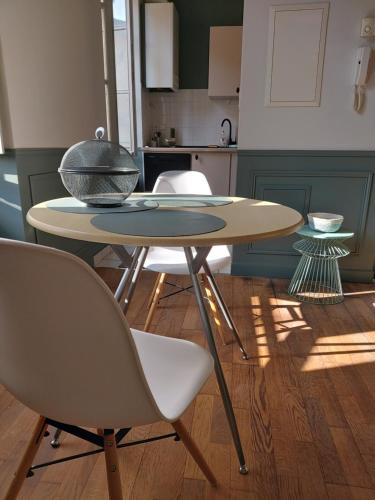 - une table avec des chaises et un bol dans la cuisine dans l'établissement Le Saint-Georges, à Villefranche-de-Rouergue