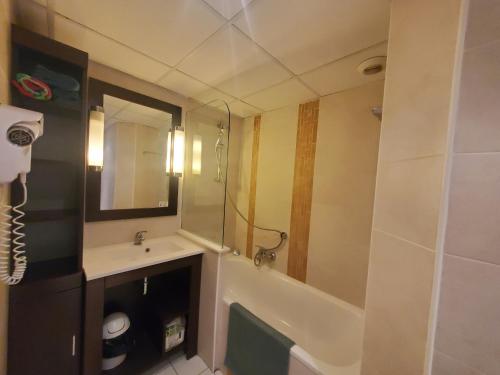 W łazience znajduje się umywalka i lustro. w obiekcie CAP HERMES Studio 31m2 Vue Port Climatise piscine, w Fréjus