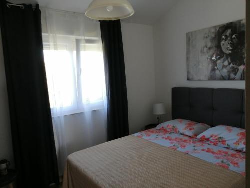 1 dormitorio con cama y ventana en Apartment Punta Skala, en Petrčane