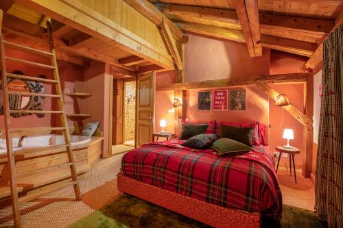 a bedroom with a red bed and a ladder at Magic Megève Bois in Demi-Quartier