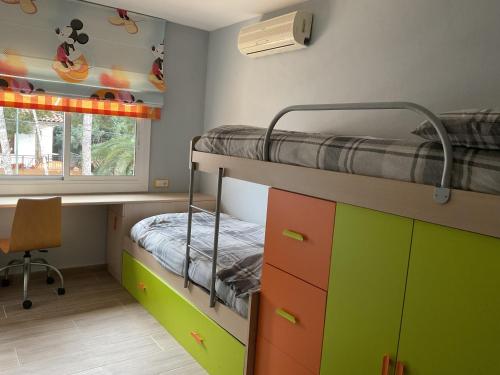 - une chambre avec des lits superposés et un bureau dans l'établissement Casa con Gran Piscina particular cerca playa, à Torredembarra