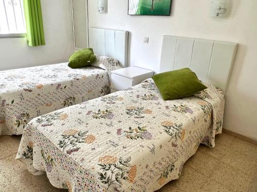 a bedroom with two beds with green pillows at Detached villa, private pool only 10 minutes to beaches in Valle de San Lorenzo