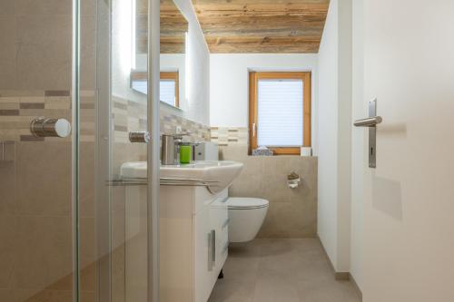 La salle de bains est pourvue d'un lavabo et de toilettes. dans l'établissement Apartments Alpenrose, à Saas-Almagell