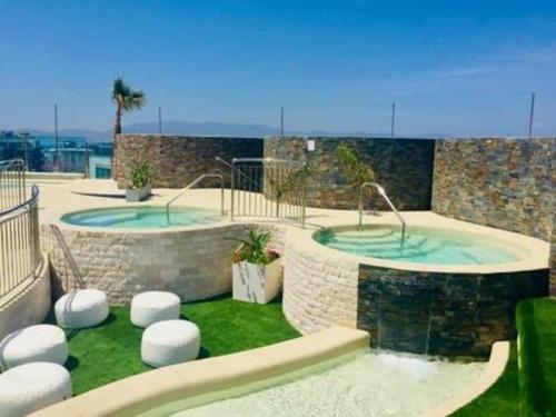 a pool with two hot tubs in a yard at 5 star Luxurious Ocean Spa Plaza in Gibraltar