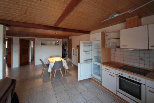 a kitchen with white cabinets and a table with chairs at Ferienwohnung Harmonie in Bad Teinach-Zavelstein