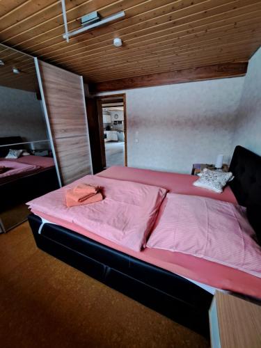 a large bed with pink sheets in a room at Ferienwohnung Harmonie in Bad Teinach-Zavelstein