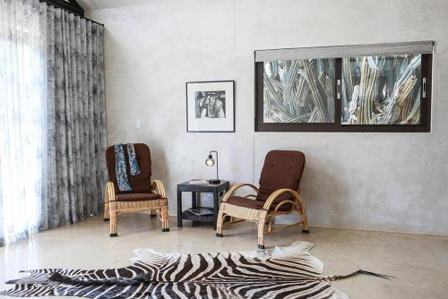 a living room with two chairs and a zebra print rug at Ibenstein Safaris in Dordabis
