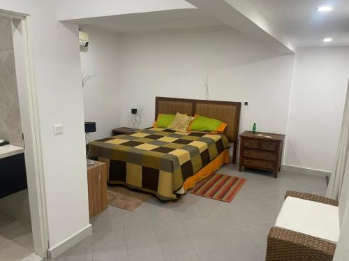 1 dormitorio con 1 cama con manta a cuadros en Casa Luxuosa na Ilha do Mussulo en Belas
