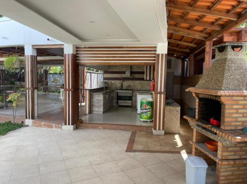 a kitchen with a fireplace and a patio at Casa Luxuosa na Ilha do Mussulo in Belas
