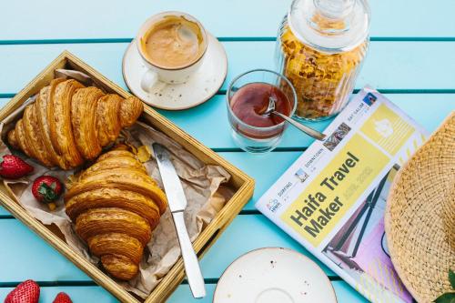 a table topped with a tray of croissants and strawberries at Domus Bat Galim Hotel in Haifa