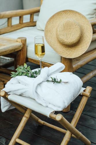 a table with a glass of wine and a hat at Domus Bat Galim Hotel in Haifa