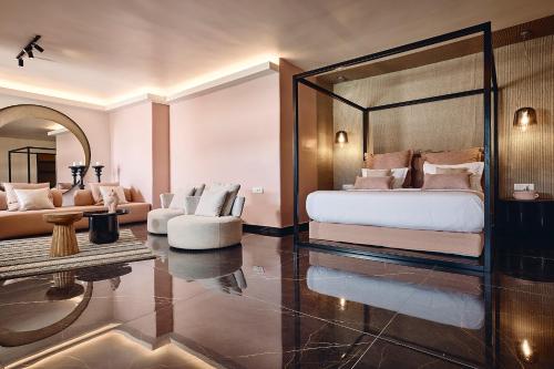 a bedroom with a bed and a living room at Amazon Mykonos Suites & Spa in Agios Ioannis Mykonos
