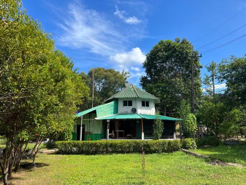 a house with a green roof in a yard at LONELY GROOVE in Ko Chang