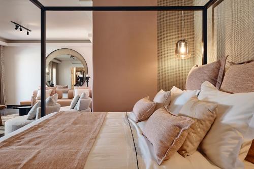 a bedroom with a large bed with pillows at Amazon Mykonos Suites & Spa in Agios Ioannis Mykonos
