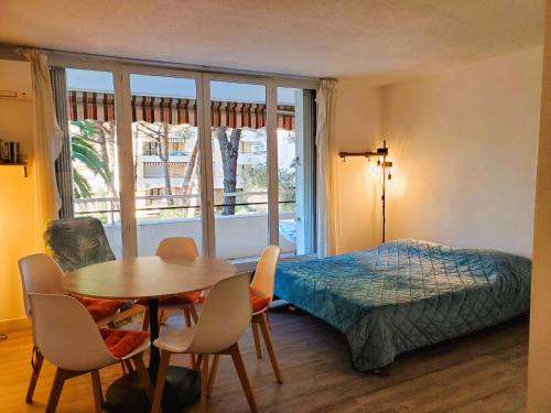 une chambre avec un lit, une table et des chaises dans l'établissement FREJUS PLAGE Miougrano T2 55m2 Climatise Piscine, à Fréjus