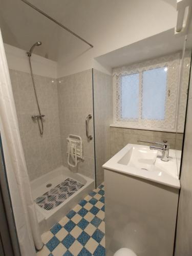 une salle de bain blanche avec un lavabo et une douche dans l'établissement le gite de flavie, à Montpeyroux