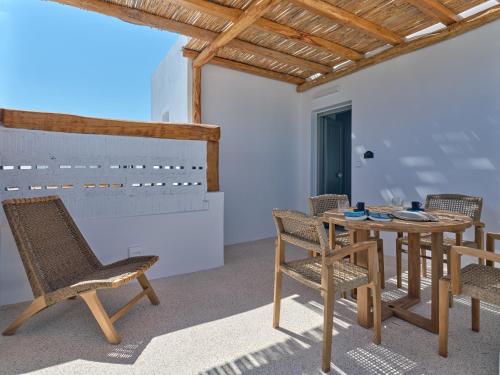 patio z krzesłami, stołem i krzesłami w obiekcie Siora of Paros - Ammiralis & Castelis w mieście Nausa