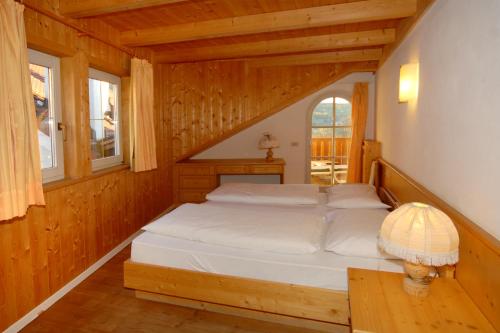 a bedroom with a bed in a wooden house at Hotel Rose Wenzer in Vols am Schlern