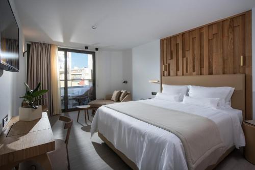 una camera d'albergo con un grande letto e una sedia di Dimargio Luxury Hotel & Spa a Heraklion
