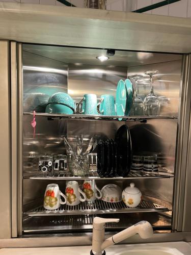 a refrigerator filled with plates and dishes in a kitchen at Loft Albinelli Wi-Fi e parcheggio gratis in centro in Modena