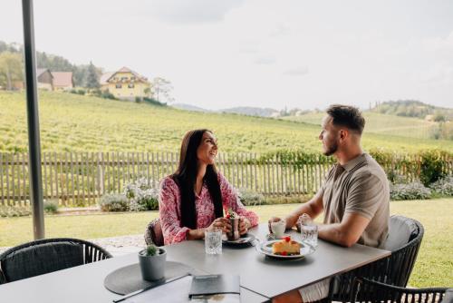 a man and a woman sitting at a table in front of a table at Ratscher Landhaus in Ratsch an der Weinstraße
