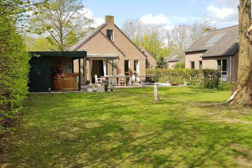 a house with a yard with a yard at De Zingende Wilg, heerlijk huisje met Hottub in Ewijk