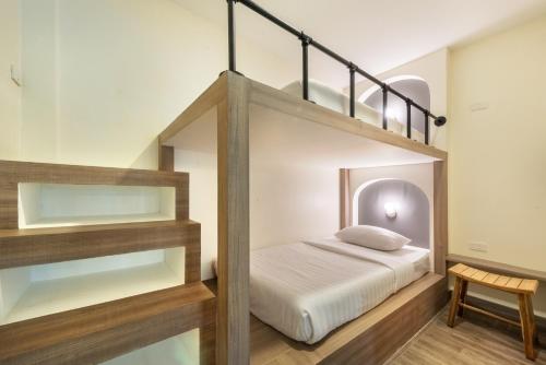 a bedroom with a bunk bed with a ladder at Qiu Hotel Sukhumvit SHA Plus in Bangkok