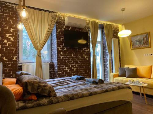 - une chambre avec un lit et un mur en briques dans l'établissement Skenderija-Cityscape apartments, à Sarajevo