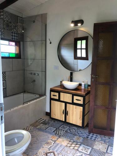 y baño con lavabo, aseo y espejo. en Cabaña La Colmena en Tigre