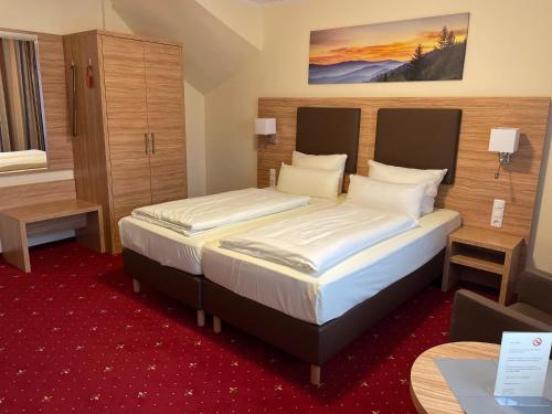 a hotel room with a bed and a desk at Hotel Harburger Hof in Hamburg